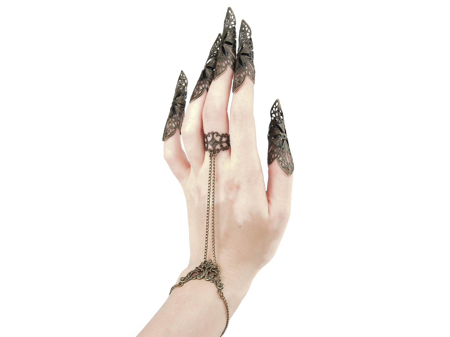 Myril Jewels presents a stunning hand chain bracelet ring and nail claw rings set, meticulously crafted for the gothic and alternative fashion enthusiast. This unique jewelry ensemble, designed with a dark avant-garde aesthetic, features elaborate filigree work and extended claws for a dramatic effect. It's the quintessential accessory for Halloween, embodying the essence of Punk, Neo Gothic, and Gothic-chic styles, and is ideal for those who embrace Whimsigoth and Witchcor