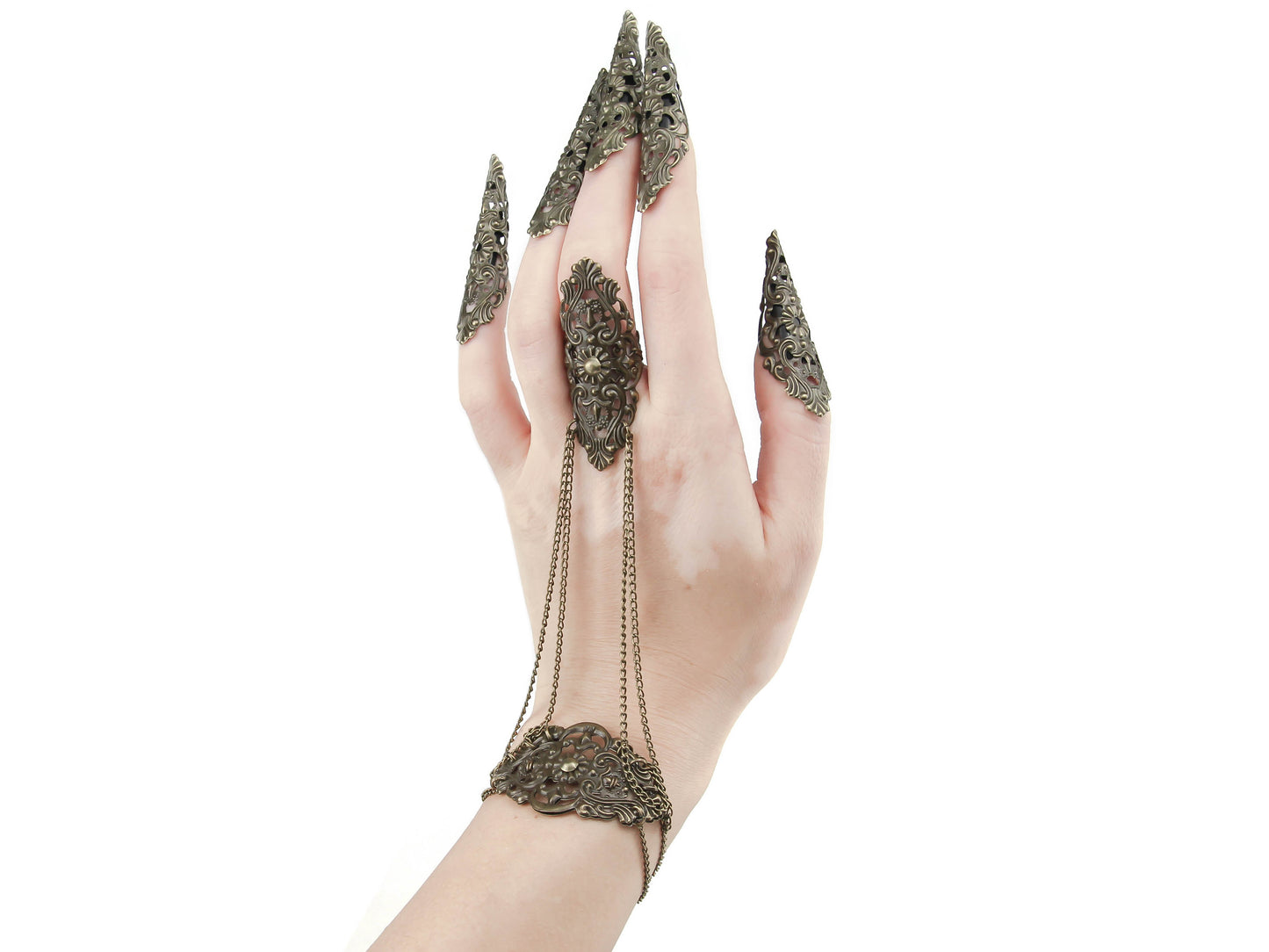 This bronze hand chain is truly stunning, featuring a gothic-inspired design that is perfect for those with a bold fashion sense. Adorned with bronze sharp nail claws, it captures the essence of goth fashion. The intricate filigree metalwork on the back of the hand adds an elegant touch, while chains connect the bracelet to the middle finger ring. Set against a white background, this meticulously crafted creation exudes a refined and mysterious charm.