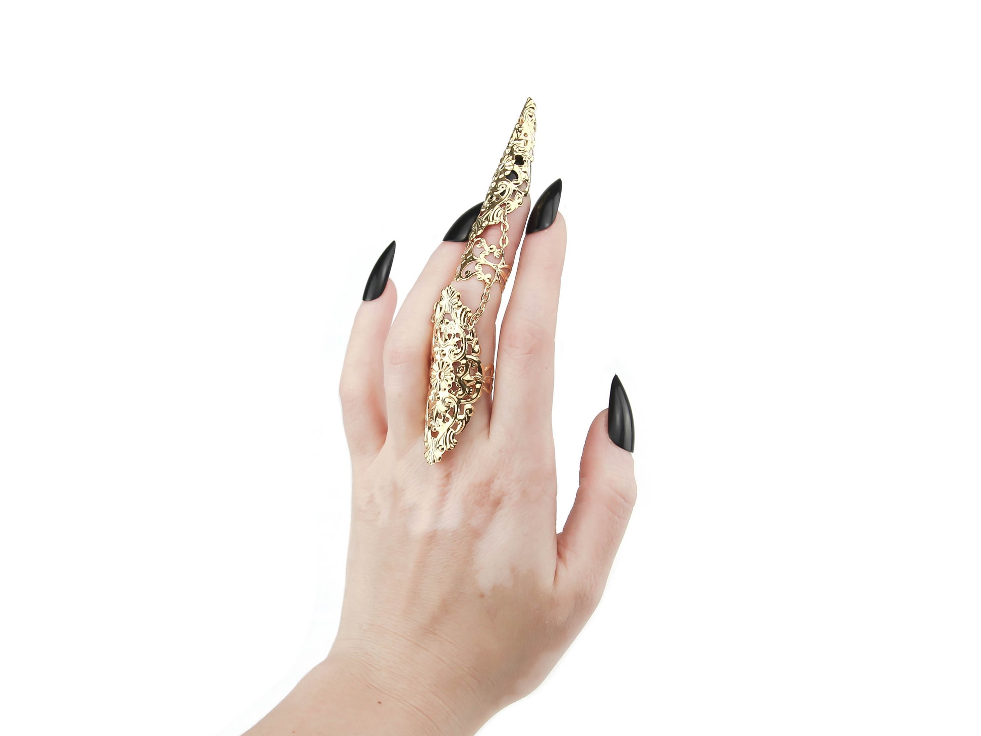 An elegant hand with black polished nails showcases a stunning Myril Jewels finger armor ring, a hallmark of dark-avantgarde style. The gold ring features elaborate filigree details, embodying the gothic and alternative aesthetic, perfect for those who dare to express their individuality with bold Italian craftsmanship.