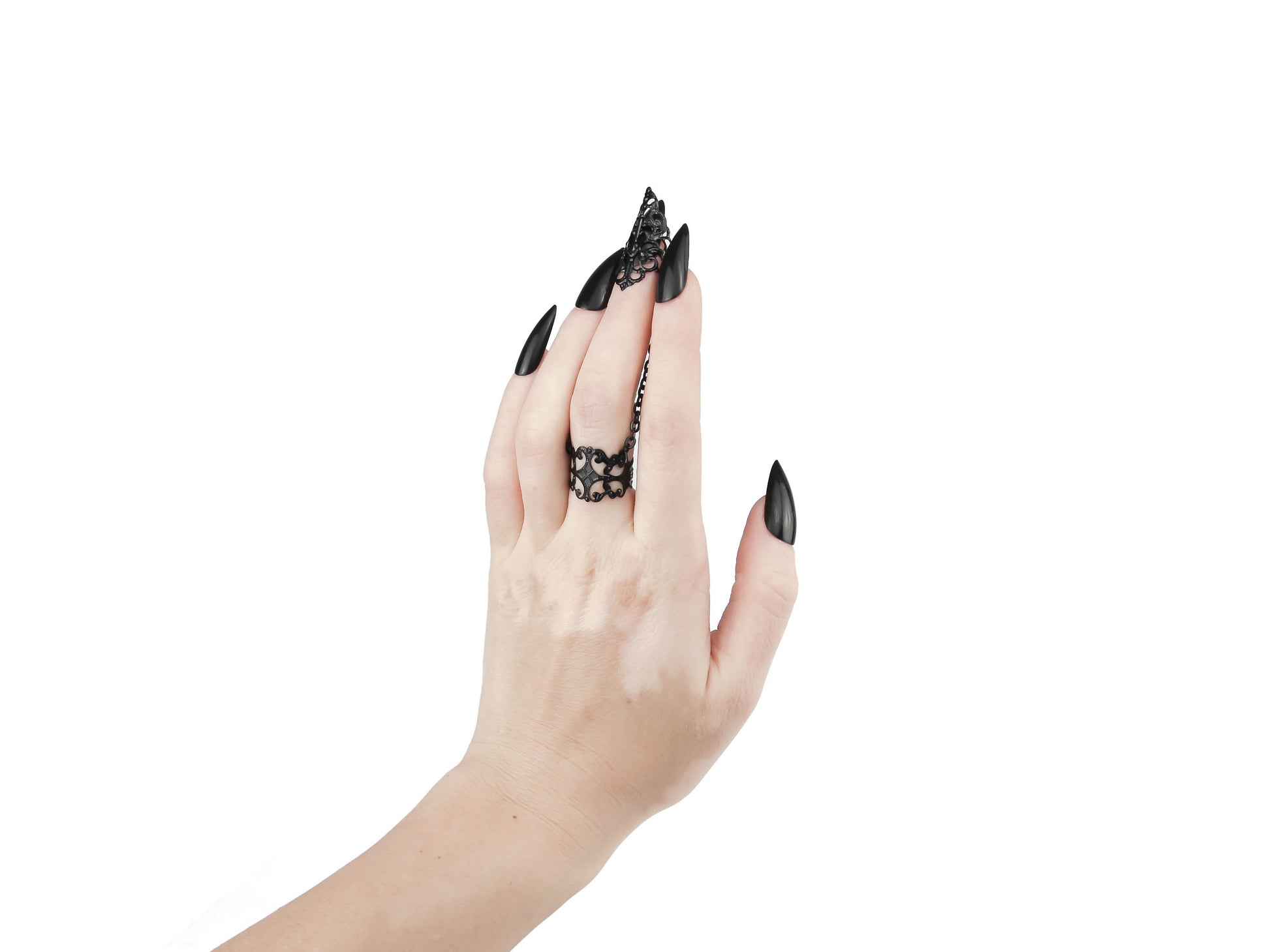 An avant-garde ring with claw from Myril Jewels, featuring intricate gothic-inspired filigree design that exudes dark elegance. The black chain connects a detailed ring to a matching claw over the nail, embodying the brand's commitment to sophisticated, futuristic gothic style. Ideal for those who appreciate gothic-chic, Neo Gothic, and Witchcore aesthetics, this piece is perfect for everyday wear, Halloween, or as a statement accessory for rave parties and festivals.