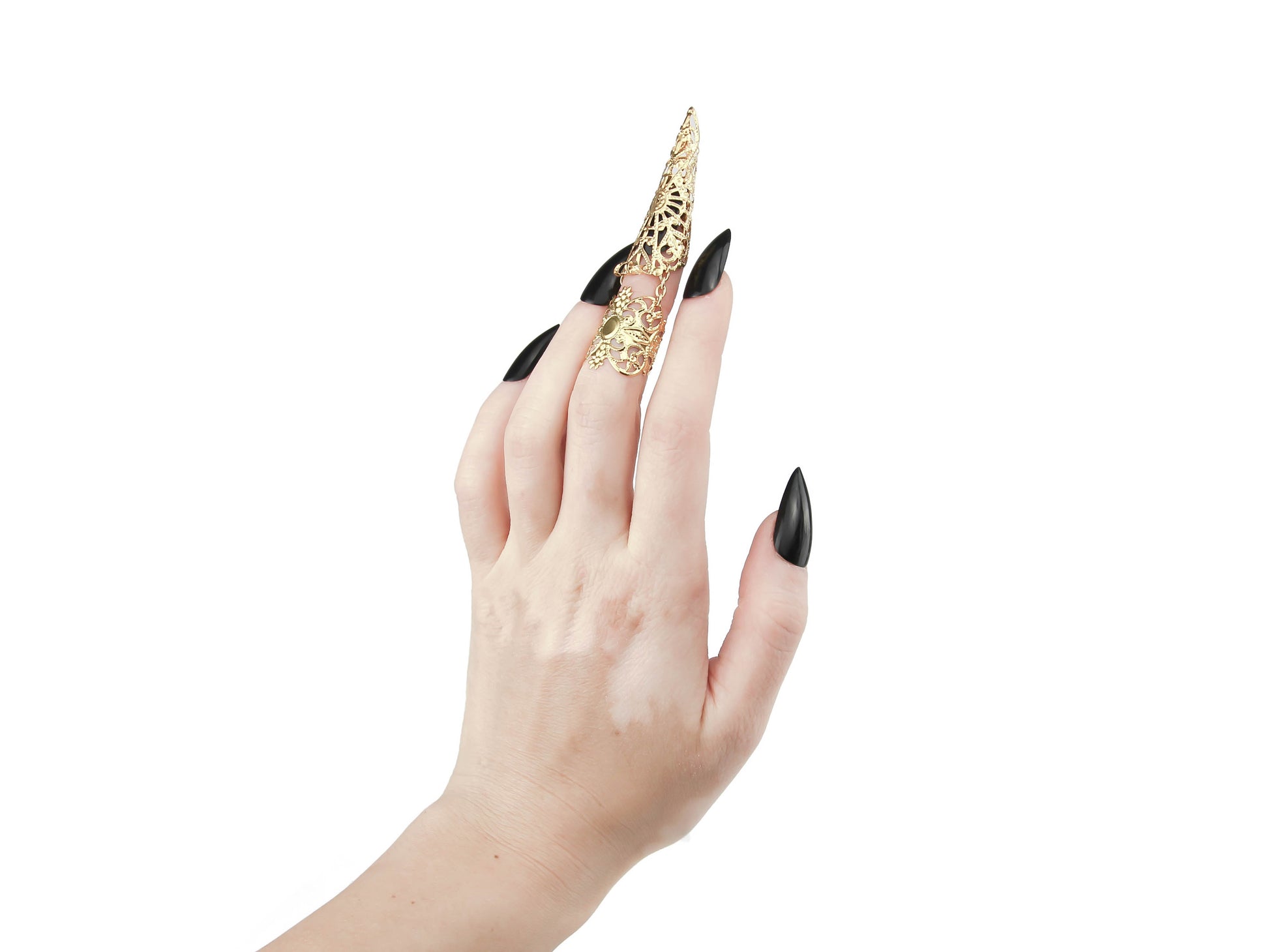This image captures a hand adorned with a Myril Jewels gold claw ring on the middle finger, its design reminiscent of Neo Gothic artistry. The midi ring, characteristic of dark-avantgarde jewelry, extends into a pointed tip that mirrors the wearer's sleek black nails, creating a seamless gothic-chic look. This statement piece is perfect for those embracing a minimal goth style or seeking an edgy accessory for Halloween, witchcore, or whimsigoth fashion statements.