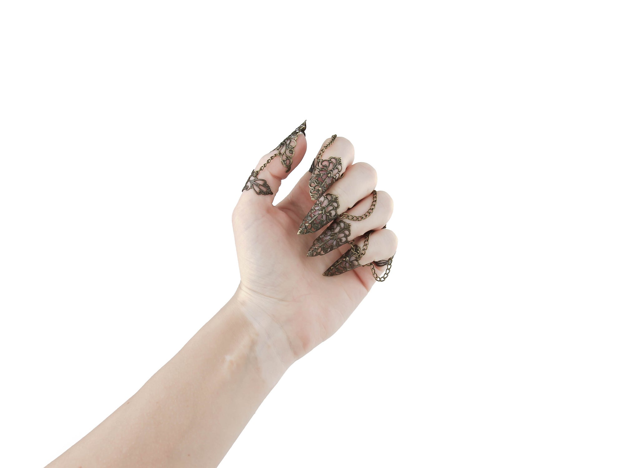 An almost closed hand adorned with Myril Jewels' full set of bronze claw rings, showcasing exquisite filigree detailing for a striking dark-avantgarde statement. Each ring, crafted with Neo Gothic intricacy, extends into an elegant point, perfect for Halloween, festival wear, or adding an edge to everyday minimal goth attire. This set aligns with gothic-chic and Witchcore aesthetics, reflecting the brand's commitment to unique, alternative jewelry designs.