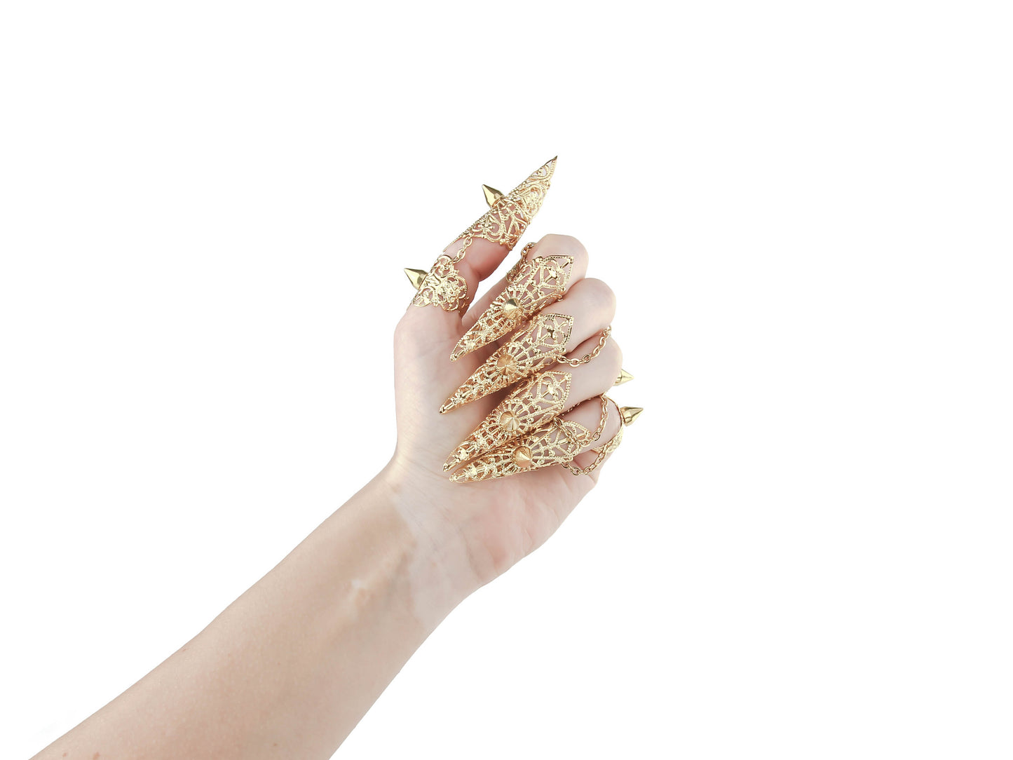 A hand is adorned with a stunning set of Myril Jewels gold claw rings, featuring intricate patterns and bold studs, perfect for a neo-gothic look. Ideal for Halloween, these pieces exemplify gothic-chic and are a dazzling addition to any rave party or festival outfit.