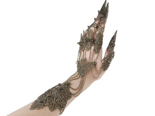 A Myril Jewels full hand armor piece extends from the fingertips to the arm, each finger tipped with long claws. Intricately designed for the neo-gothic aficionado, this exquisite piece suits a dramatic Halloween ensemble, punk events, or whimsigoth-inspired wear. It's the perfect accessory for festival goers, drag queens, or as a bold and unique gift for the goth girlfriend who appreciates the darker side of elegance.