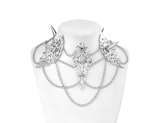 An intricately designed Myril Jewels studded choker featuring ornate filigree details and sharp, spiked elements. This bold, gothic-chic piece is interlaced with multiple chains, creating a captivating, layered look ideal for festival wear, drag queen ensembles, or as a standout gift for goth style lovers.