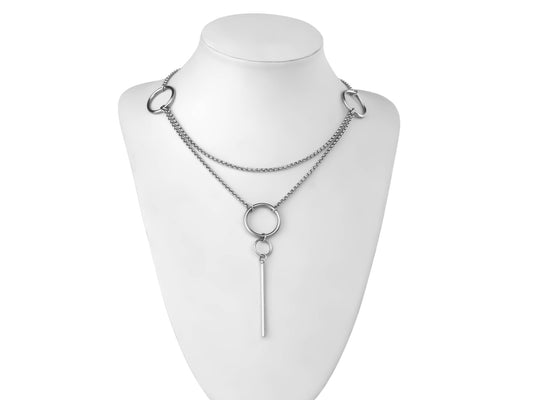 Displayed on a white mannequin, a Myril Jewels minimal chain necklace features symmetric hoops and a sleek drop pendant. This piece is a testament to understated neo-goth elegance, ideal for adding a refined edge to any ensemble, whether it’s for Halloween, daily wear, or a special gift.