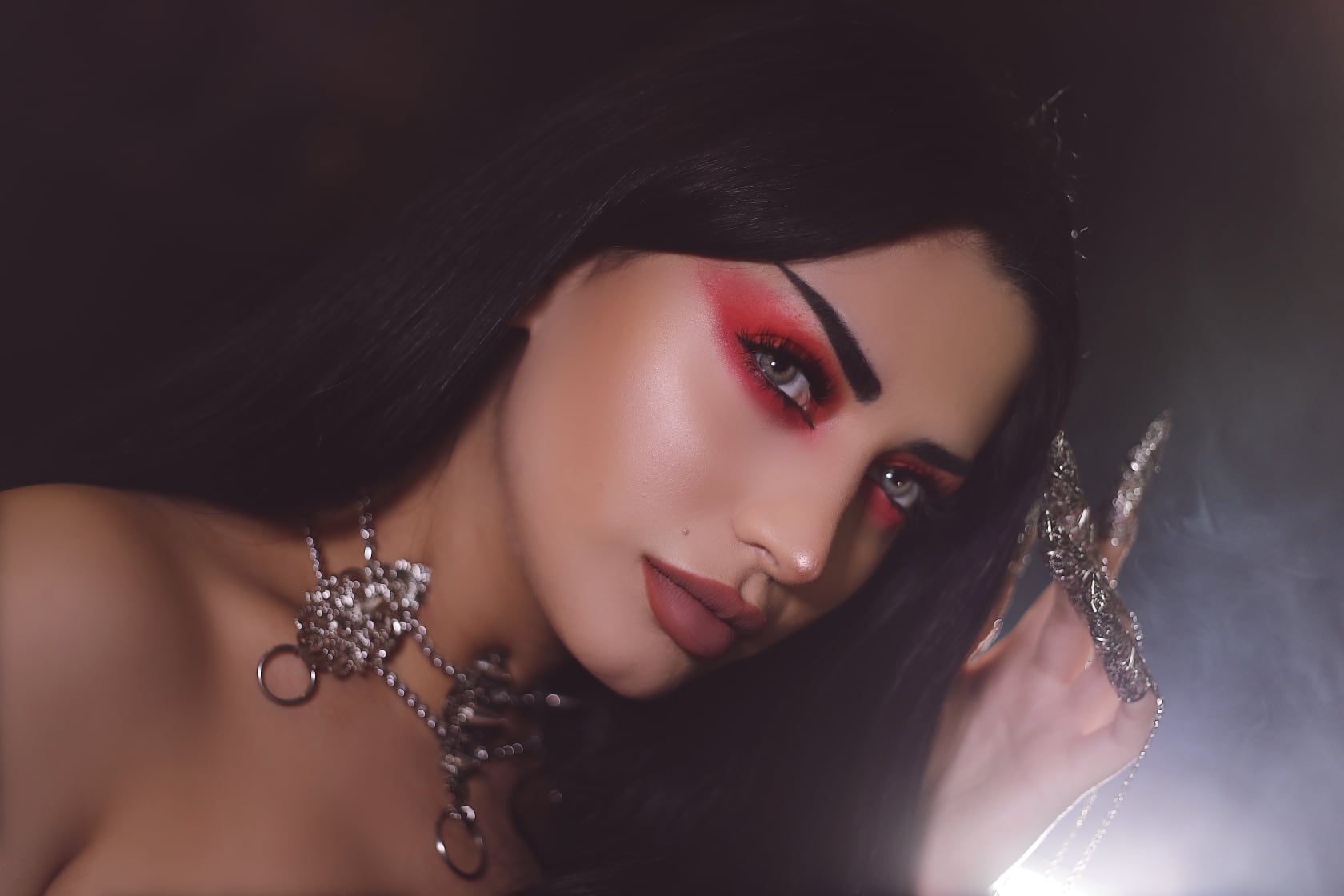 In this evocative image, an alt model adorned with Myril Jewels' punk studded metal choker captivates with her gothic allure. The choker's detailed metalwork, emblematic of Neo Gothic artistry, complements the model's dramatic red eyeshadow and the mysterious ambiance. This Myril creation is perfect for those who embrace Halloween jewelry, punk fashion, or the everyday wear of Gothic Lolita, Gothic-chic, whimsigoth, or witchcore styles, offering a bold statement for minimal goth enthusiasts