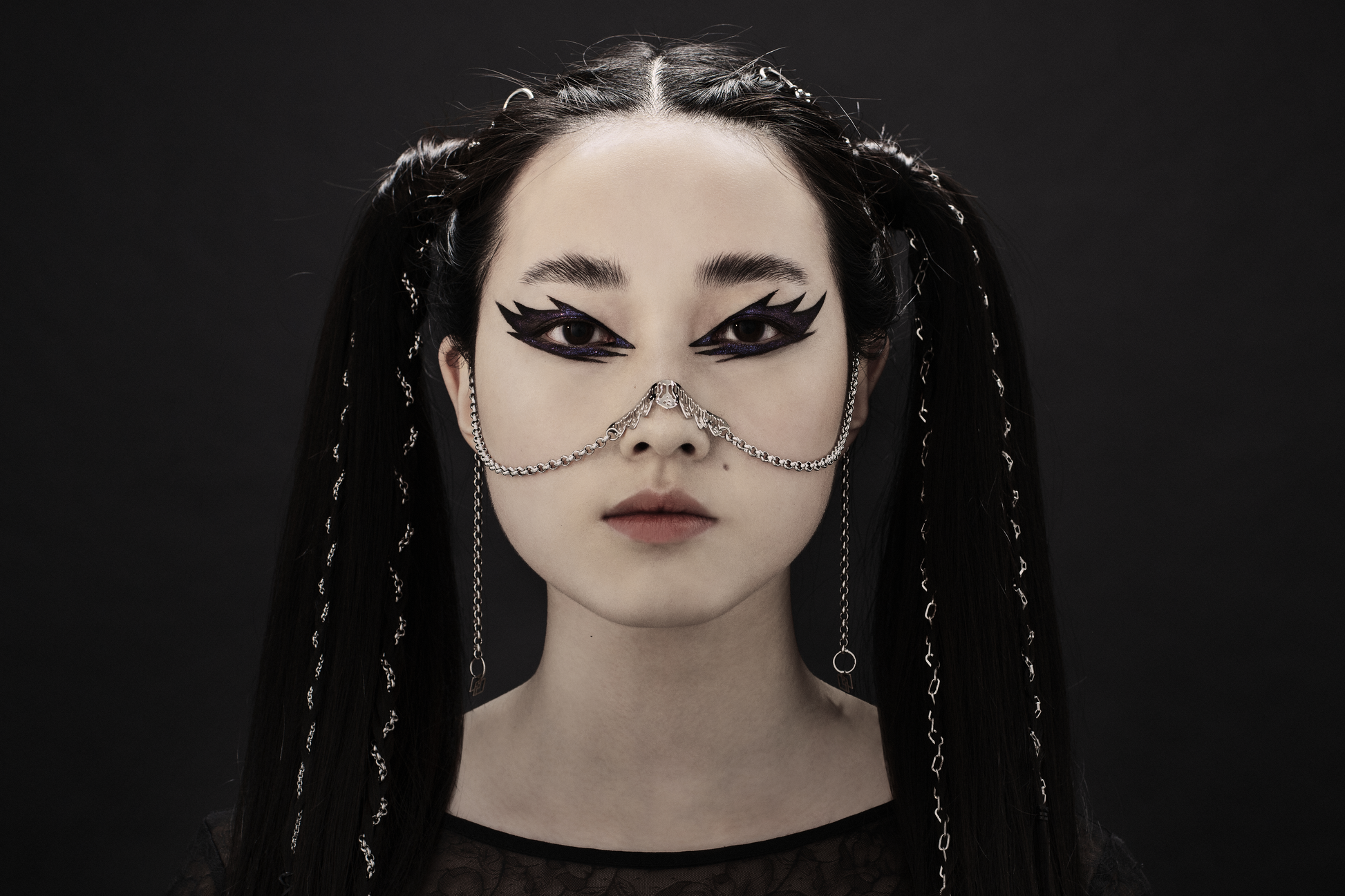 A model exudes dark elegance with a Myril Jewels nose chain, a statement piece evoking neo-gothic and witchcore vibes. Perfect for gothic-chic fashion, it's an ideal accessory for Halloween, festivals, or bold everyday wear, and makes a striking goth girlfriend gift.