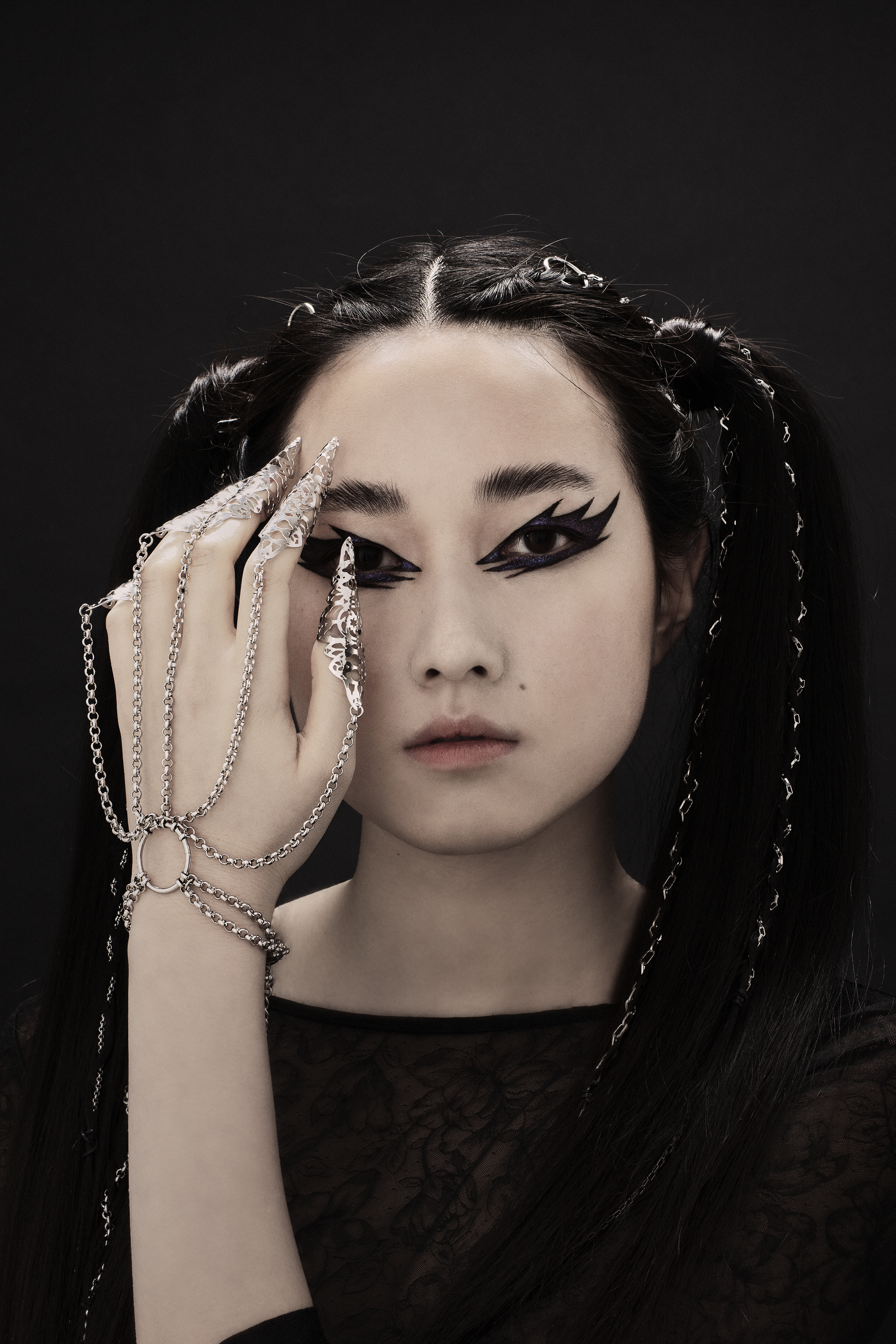 A dramatic hand chain bracelet with nail claws from Myril Jewels enhances the beauty of a gothic look. With its neo-gothic flair, this jewelry piece is a striking choice for Halloween, goth-inspired everyday wear, or as a bold accent for festival outfits and drag queen glamor.