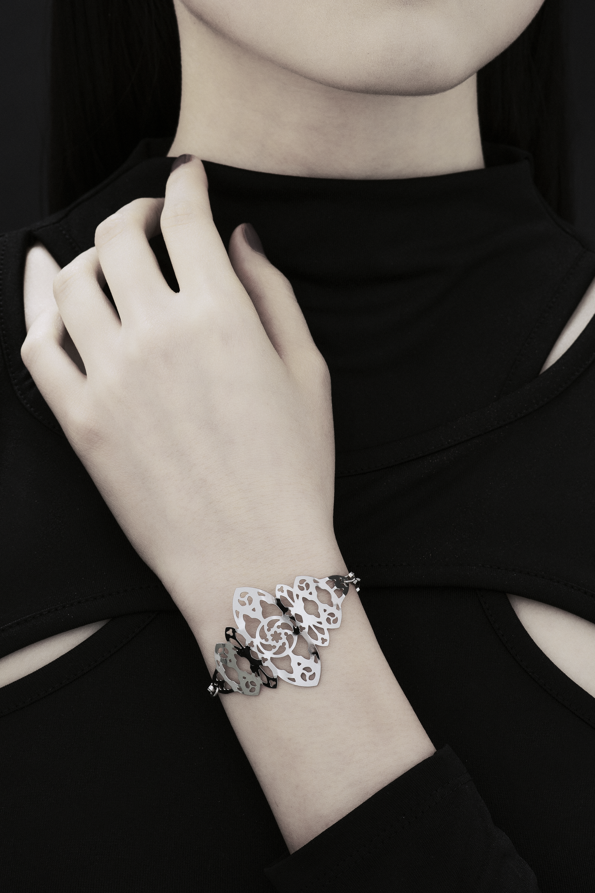 A model poses with a Myril Jewels bracelet inspired by gothic architecture, the intricate design reminiscent of cathedral windows. This statement piece is perfect for those who favor neo-goth style, making it a suitable accessory for a variety of occasions, from everyday wear to special events like festivals or Halloween.