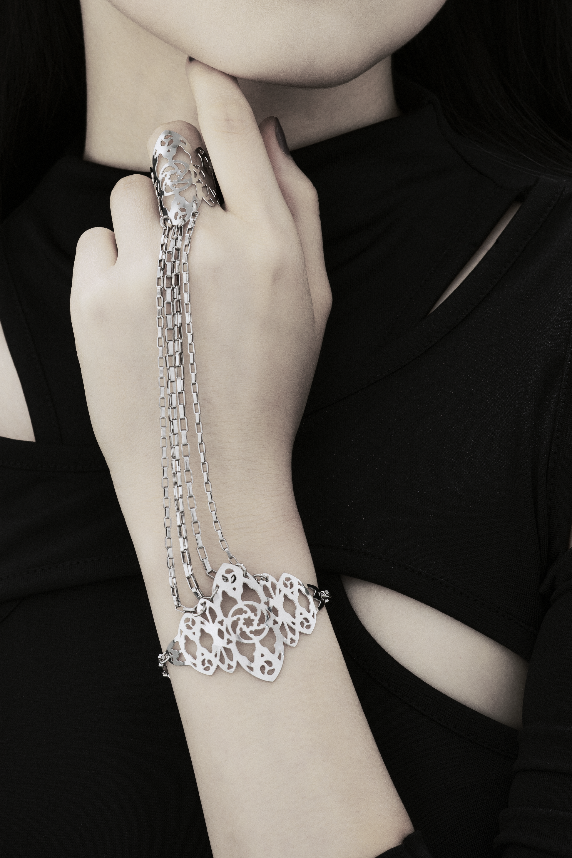 The photo captures a hand elegantly adorned with a Myril Jewels hand chain, featuring intricate gothic arches inspired filigree that cascades down the wrist. It's a perfect blend of neo-gothic style and dark romance, ideal for those who appreciate a touch of avant-garde in their everyday wear or for making a statement at a gothic-chic event.