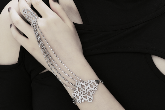 The photo captures a hand elegantly adorned with a Myril Jewels hand chain, featuring intricate gothic arches inspired filigree that cascades down the wrist. It's a perfect blend of neo-gothic style and dark romance, ideal for those who appreciate a touch of avant-garde in their everyday wear or for making a statement at a gothic-chic event.