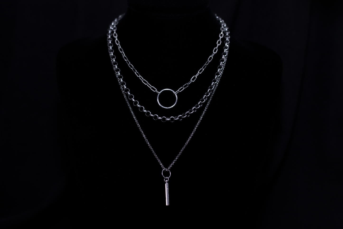 A striking Myril Jewels punk multi-chain necklace set against a black backdrop, featuring layered chains and a central hoop, epitomizing the bold, dark-avantgarde style of neo-goth fashion.