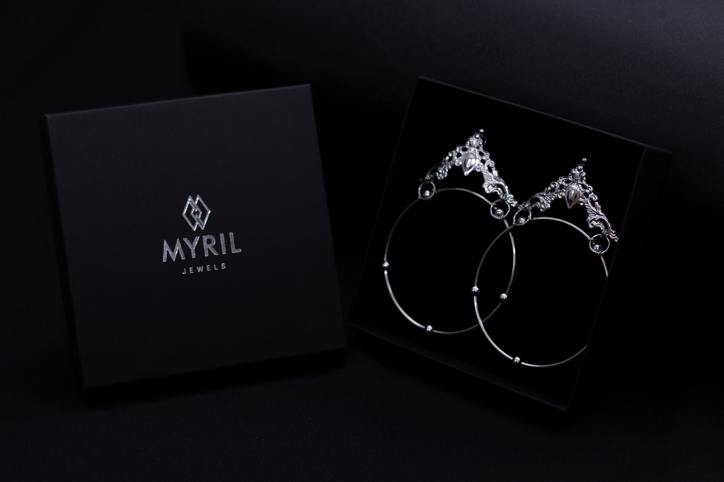 Elegant Myril Jewels gothic hoop earrings, presented in a sleek black box, exemplify neo-gothic charm. These bold, wide hoops are perfect for those embracing a dark-avantgarde aesthetic, making an ideal gift for the goth girlfriend or a unique friend gift idea