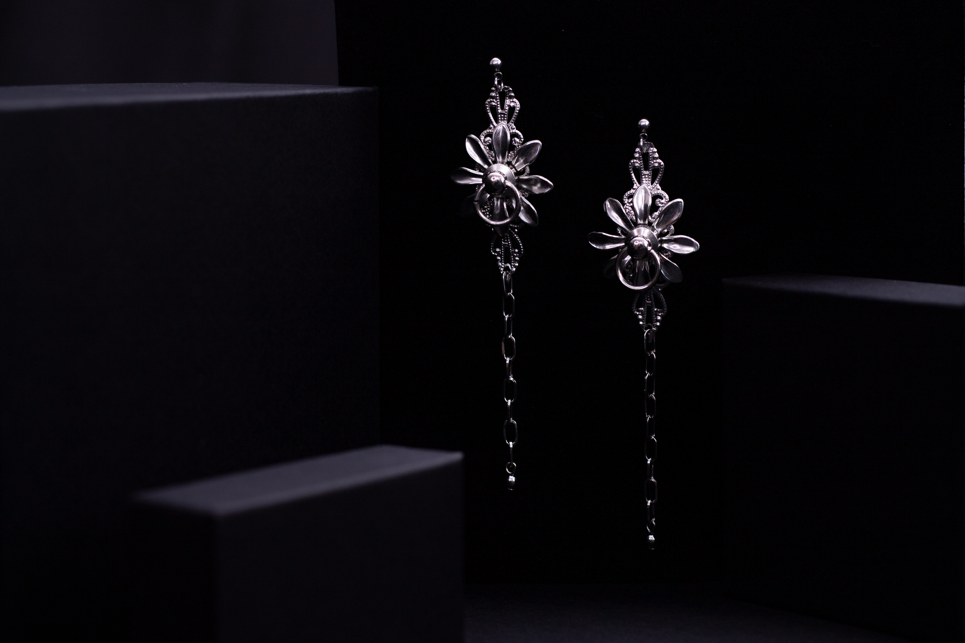 Adorned with Myril Jewels' neo-gothic floral earring, this image captures a sleek design ideal for gothic-chic enthusiasts. The earring showcases a floral motif set in dark, polished metal with a cascading chain detail, blending everyday wear with a bold statement perfect for Halloween, rave parties, or as a distinctive goth girlfriend gift