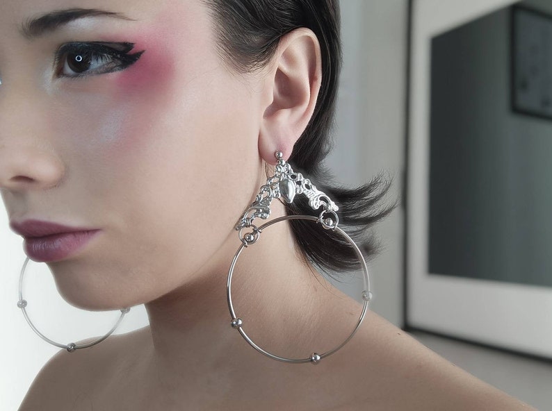A model showcases Myril Jewels' gothic hoop earrings, bold and wide with ornate details, embodying neo-goth elegance—perfect for witchcore fashion or as a unique goth girlfriend gift