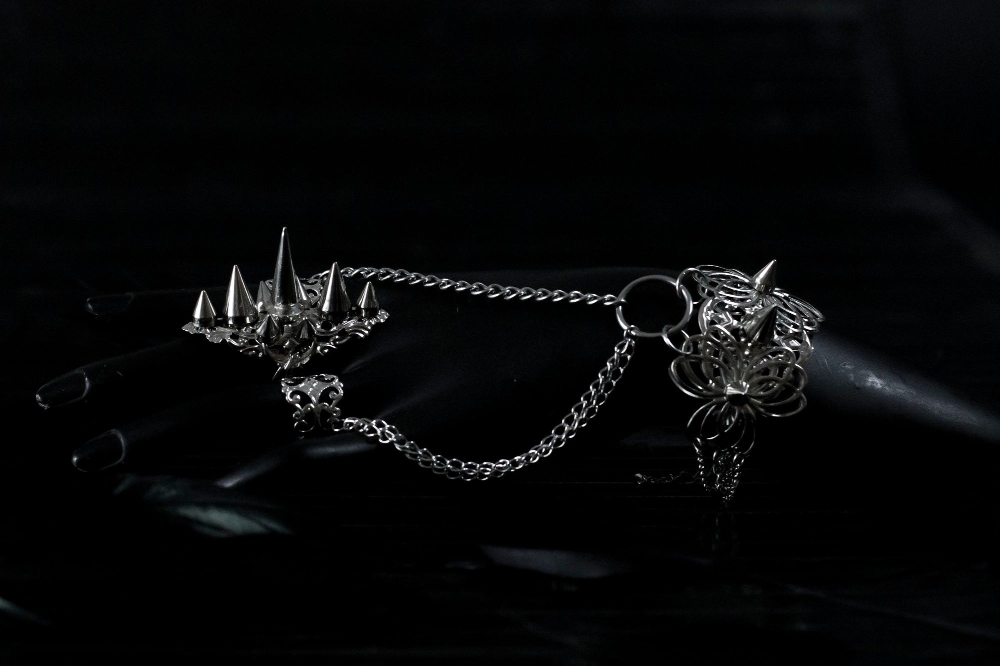 Capture the essence of punk rebellion with Myril Jewels' edgy studded ring and matching hand chain bracelet ring. These bold statement pieces, with its sharp studs and metallic finish, are a must-have for lovers of dark-avantgarde and gothic accessories. Ideal for Halloween, it also complements everyday minimal goth looks, Witchcore styles, and Gothic-chic ensembles, offering a versatile addition to any Neo Gothic jewel collection
