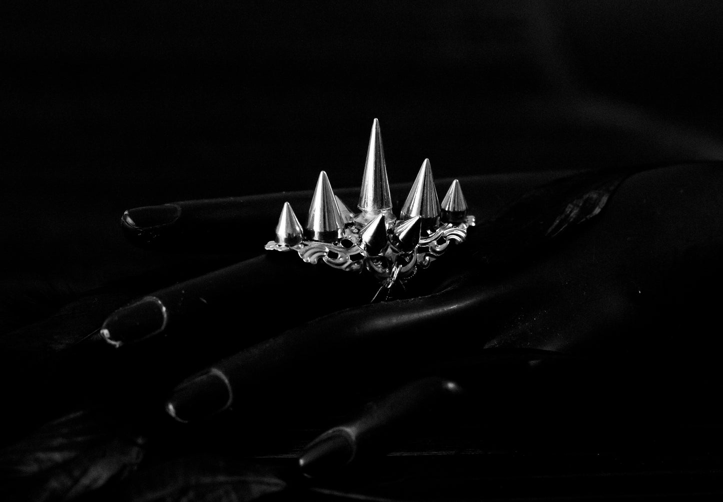 Myril Jewels' punk studded ring is a bold statement piece, meticulously crafted with a fierce array of silver spikes rising in a crown-like silhouette. This ring is a quintessential emblem of Neo Gothic style, designed for those who embody the gothic-chic lifestyle. Ideal for Halloween, it's a standout accessory for everyday wear by those who favor the Witchcore aesthetic, and a must-have for any minimal goth or Whimsigoth-inspired collection