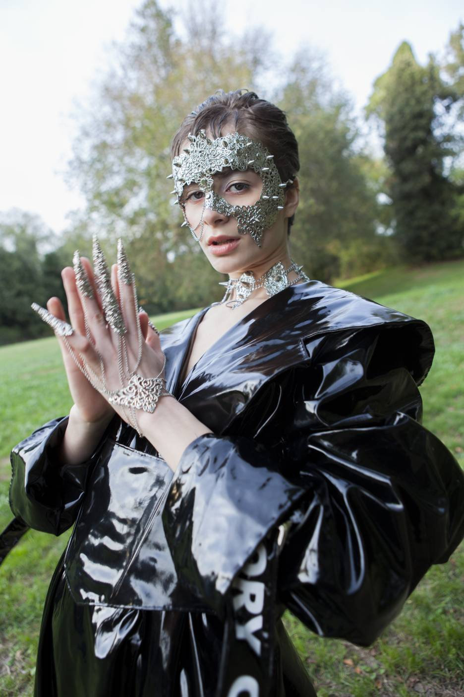 A model poses for a high-fashion shoot, showcasing Myril Jewels' punk studded metal choker that exudes dark avant-garde elegance. This piece reflects the brand's dedication to gothic and alternative styles, making it a perfect fit for lovers of Neo Gothic, Gothic Lolita, and Gothic-chic aesthetics. With intricate metalwork, it's a versatile accessory for Halloween, whimsigoth, witchcore, or as a striking addition to everyday minimal goth wardrobes