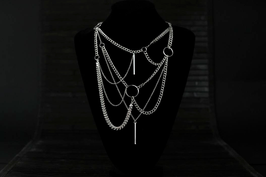 Multi-layered Myril Jewels necklace, showcasing a neo-goth aesthetic with an array of chains and an o-ring, perfect for a bold gothic-chic statement. Ideal for Halloween, rave parties, or as an everyday wear piece for those who embrace a dark avant-garde style.