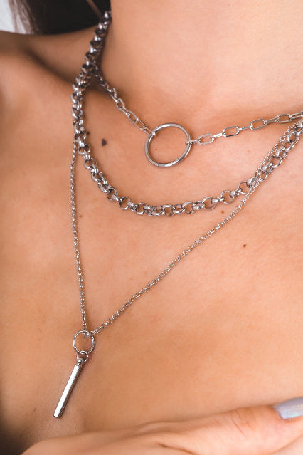 A model poses elegantly wearing a Myril Jewels punk multi-chain necklace featuring layered chains and a central hoop, reflecting a dark-avantgarde aesthetic. The accessory is perfect for those embracing a neo-gothic style, suitable for various occasions, from everyday wear to Halloween and festival events.