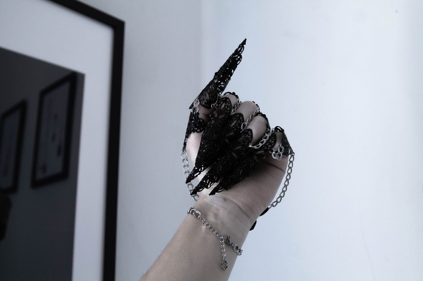 Immerse in the allure of Myril Jewels' black metal glove, a breathtaking embodiment of dark-avantgarde artistry. This hand-crafted masterpiece features elongated claw rings on each finger, creating an armor-like effect that captivates the essence of Neo Gothic style. Ideal for those drawn to the Gothic-chic and Witchcore aesthetics, this glove is a statement piece for Halloween, everyday minimal goth, and is bound to be the centerpiece in any Punk or Whimsigoth wardrobe.