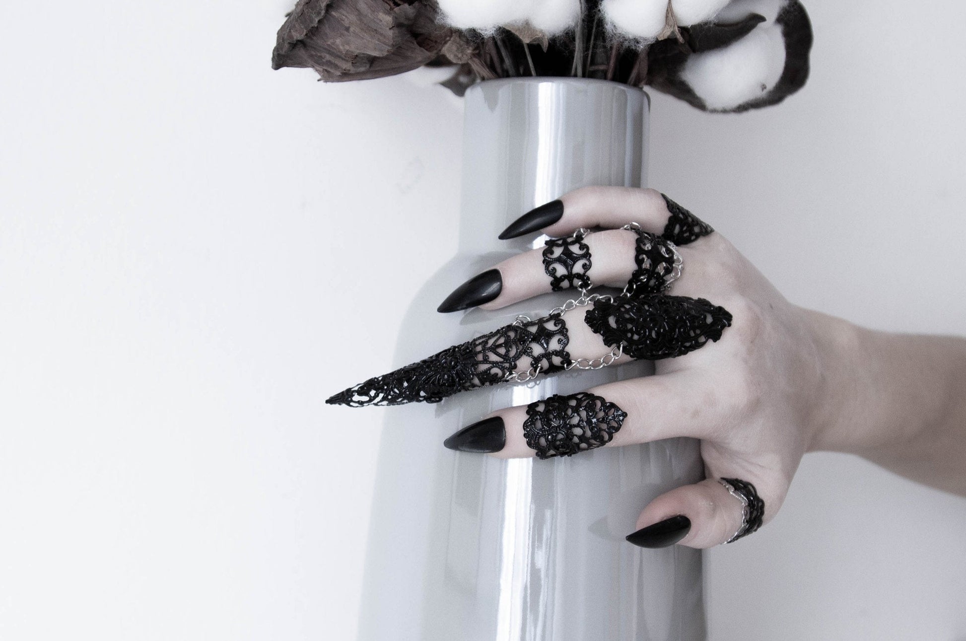 Hand adorned with Myril Jewels' eclectic ring set, featuring neo-gothic designs for a darkly elegant look. Ideal for Halloween, these bold, witchcore-inspired pieces are perfect for goth girlfriends, making a statement at rave parties or as unique friend gifts.