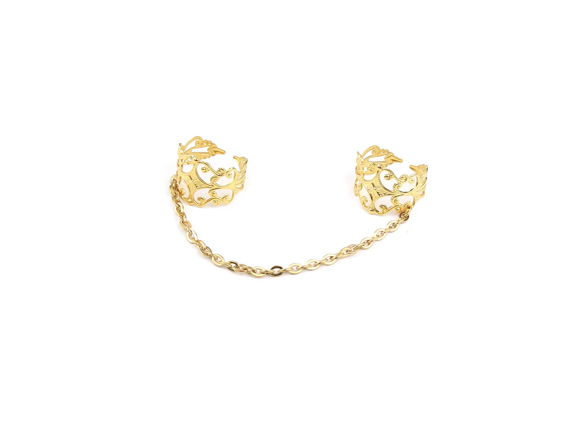 Intricately designed Myril Jewels double ring in gold tone featuring baroque-inspired motifs, connected by a delicate gold stainless steel chain, epitomizing the brand's signature dark-avantgarde aesthetic. This handcrafted Italian jewelry is perfect for those embracing gothic and alternative styles, blending elements of Neo Gothic and Gothic-chic. Ideal for adding a sophisticated yet edgy touch to Halloween, Punk, or Whimsigoth ensembles, this piece captures the essence of Witchcore