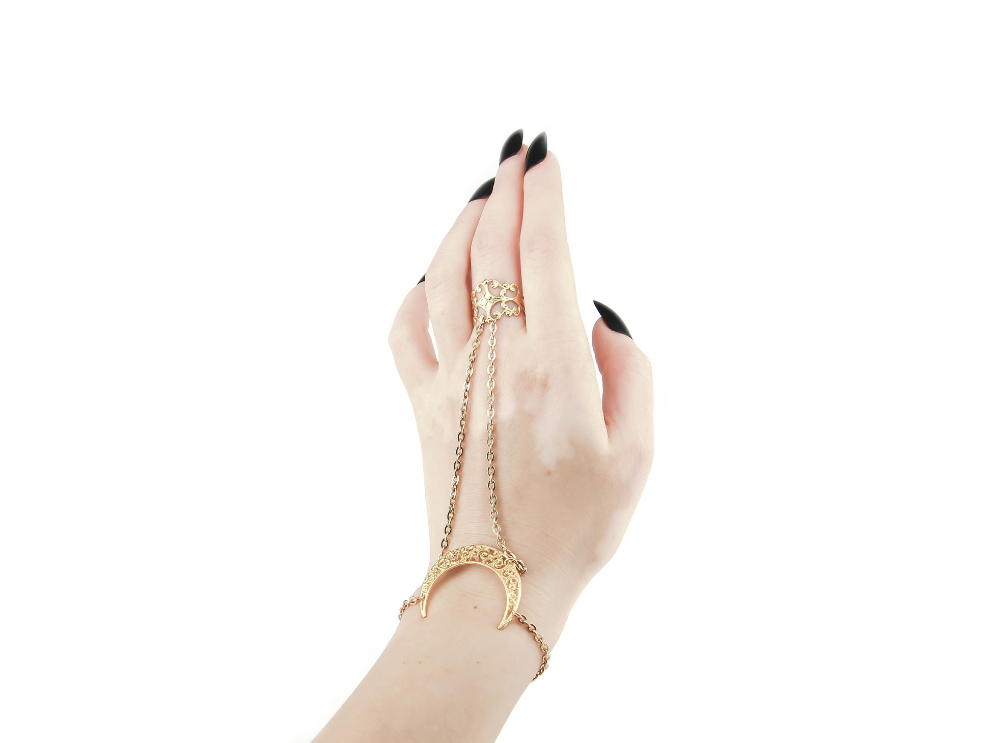 A delicate hand is raised, displaying a Myril Jewels gold hand chain with a crescent moon-shaped bracelet. This elegant piece melds neo-gothic charm with a celestial touch, suitable for anyone who cherishes dark-avantgarde aesthetics, and serves as an enchanting accessory for various occasions or as a thoughtful gift.