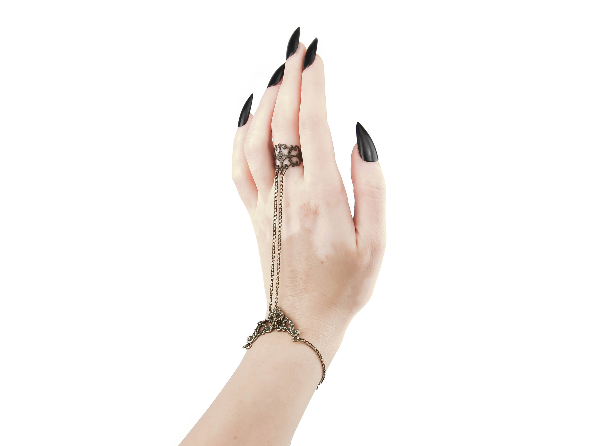 Elegant hand adorning a Myril Jewels hand chain bracelet ring, showcasing delicate bronze filigree detailing symbolic of Neo Gothic artistry. The bracelet, part of a dark avant-garde collection, embodies gothic-chic style, making it a perfect accessory for Halloween, everyday wear, or as a statement piece at rave parties and festivals. It's designed for those who appreciate Whimsigoth and Witchcore aesthetics or seek to enhance their minimal goth attire.