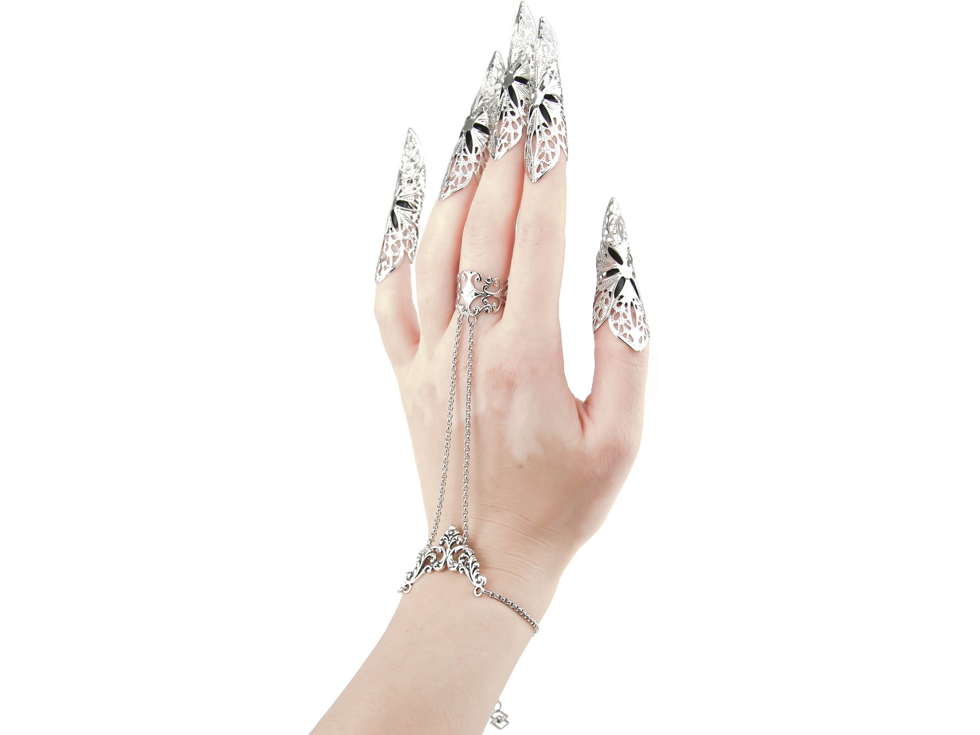Myril Jewels presents a hand chain bracelet ring paired with striking long nail claw rings, embodying the essence of dark avant-garde jewelry. This statement set, perfect for gothic, punk, and neo-gothic enthusiasts, features intricate filigree that captivates the eye, ideal for Halloween, everyday wear, or as a dramatic accessory for rave parties and festivals. The bold design exudes a Witchcore vibe, appealing to those who dare to stand out with gothic-chic elegance