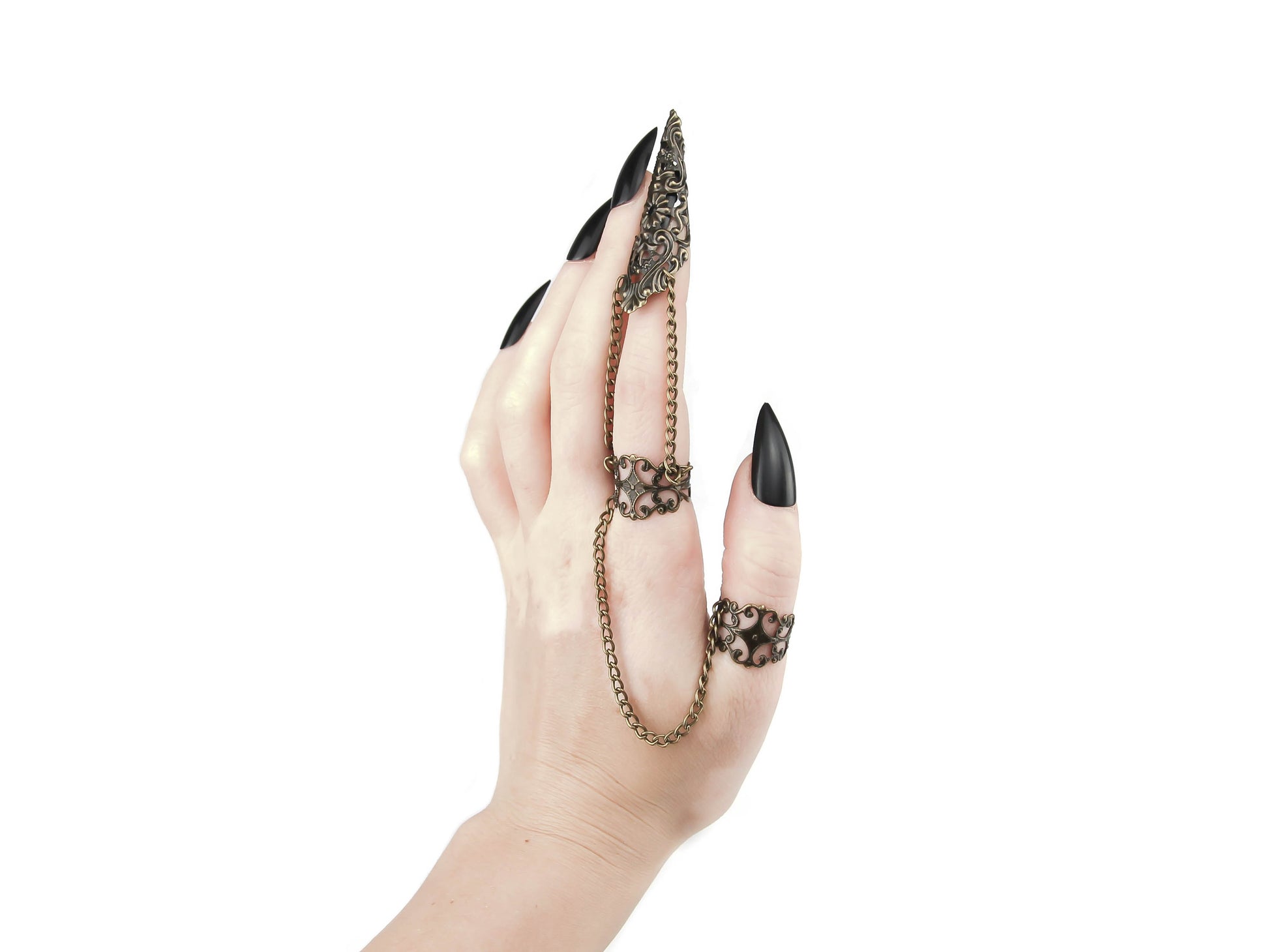 A striking Myril Jewels double ring extends into elegant claws over the fingers, showcasing a detailed bronze filigree design that captures the essence of neo-gothic style. This bold piece is ideal for anyone who gravitates towards dark, avant-garde fashion, making it a fitting accessory for Halloween, a statement piece for everyday witchcore, or an edgy complement to minimal goth, rave party, or festival jewels.