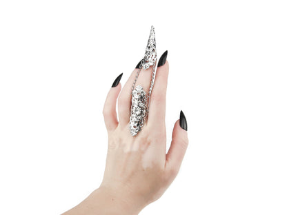 A hand models a Myril Jewels silver claw ring, its intricate black filigree embracing the wearer’s middle finger with gothic grace. This piece is a testament to the neo-goth aesthetic, a perfect addition to a Halloween ensemble or punk look. Designed for those who favor gothic-chic and whimsigoth trends, it's versatile enough for everyday wear, rave parties, or festivals, and makes a bold statement as a gift for a goth girlfriend.