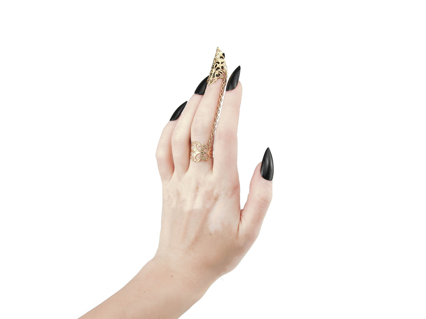 An avant-garde gold claw ring from Myril Jewels, featuring intricate gothic-inspired filigree design that exudes dark elegance. The chain connects a detailed ring to a matching claw over the nail, embodying the brand's commitment to sophisticated, futuristic gothic style. Ideal for those who appreciate gothic-chic, Neo Gothic, and Witchcore aesthetics, this piece is perfect for everyday wear, Halloween, or as a statement accessory for rave parties and festivals.