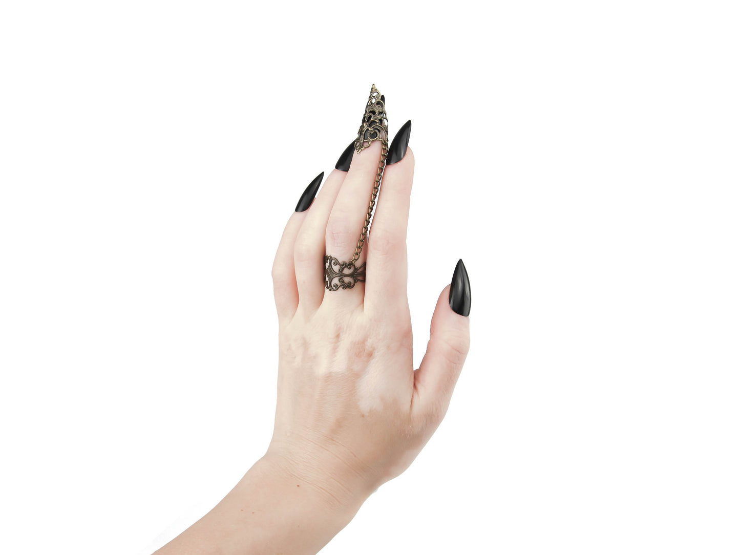 An avant-garde bronze ring with claw from Myril Jewels, featuring intricate gothic-inspired filigree design that exudes dark elegance. The chain connects a detailed ring to a matching claw over the nail, embodying the brand's commitment to sophisticated, futuristic gothic style. Ideal for those who appreciate gothic-chic, Neo Gothic, and Witchcore aesthetics, this piece is perfect for everyday wear, Halloween, or as a statement accessory for rave parties and festivals.