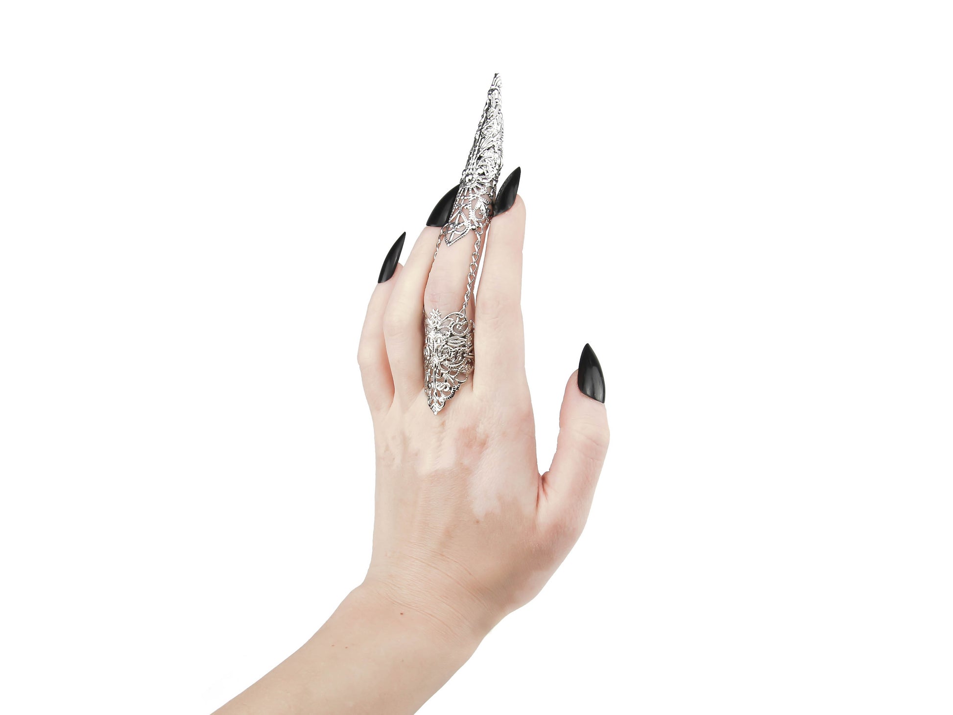 A hand models a Myril Jewels full finger claw ring, featuring elaborate silver filigree work that defines neo-goth jewelry. The ring extends over the finger with a tapered, ornate design, ideal for a dramatic gothic-chic statement. It's a striking piece for Halloween, an edgy accessory for everyday wear, and perfect for witchcore, whimsigoth, or minimal goth fashion. This claw ring is also a dazzling choice for rave party jewelry, festival adornments, or drag queen jewels.
