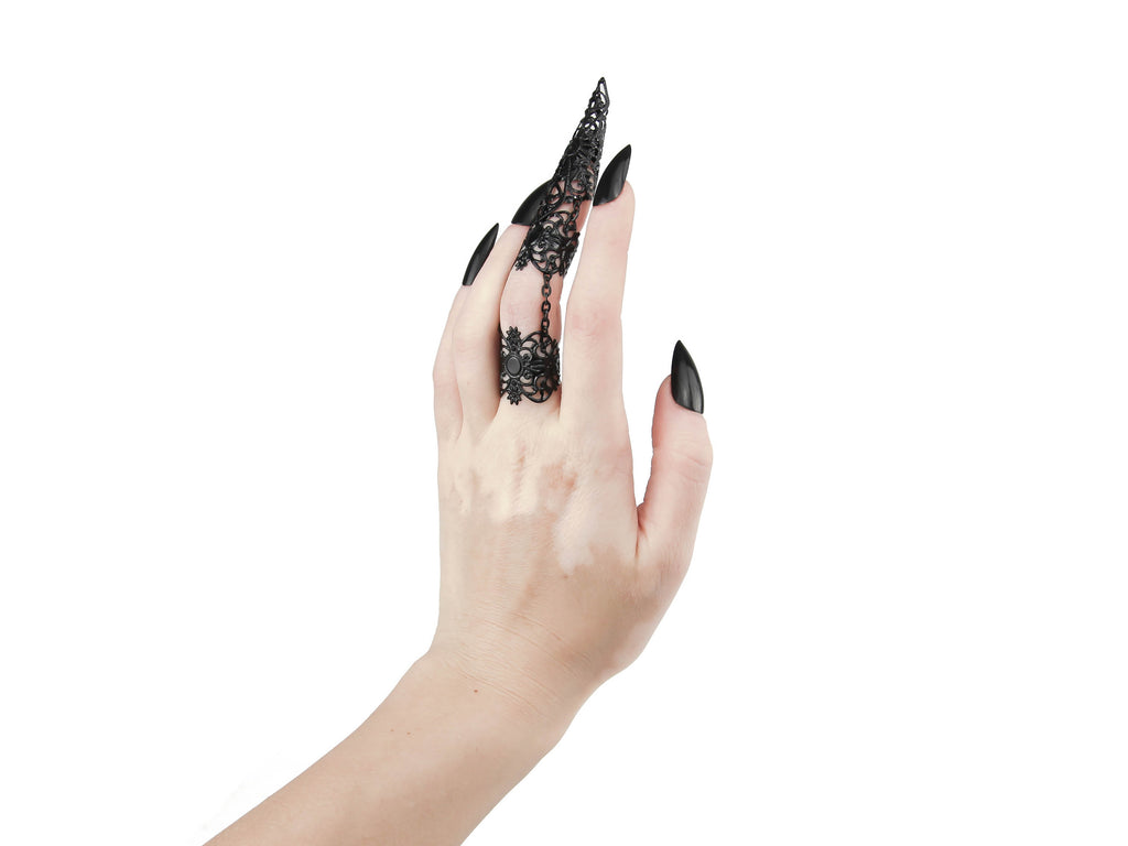 Experience the allure of the dark and avant-garde with Myril Jewels' handcrafted armor-like ring, a statement piece for the modern goth. This Neo Gothic claw ring, showcased on a hand with matching black nails, exemplifies the bold and unique aesthetics of gothic-chic. Perfect for those who embrace a witchcore or whimsigoth lifestyle, it adds a touch of edgy sophistication to any outfit. This ring is a versatile accessory that seamlessly transitions from Halloween celebrations to everyday minimal goth wear