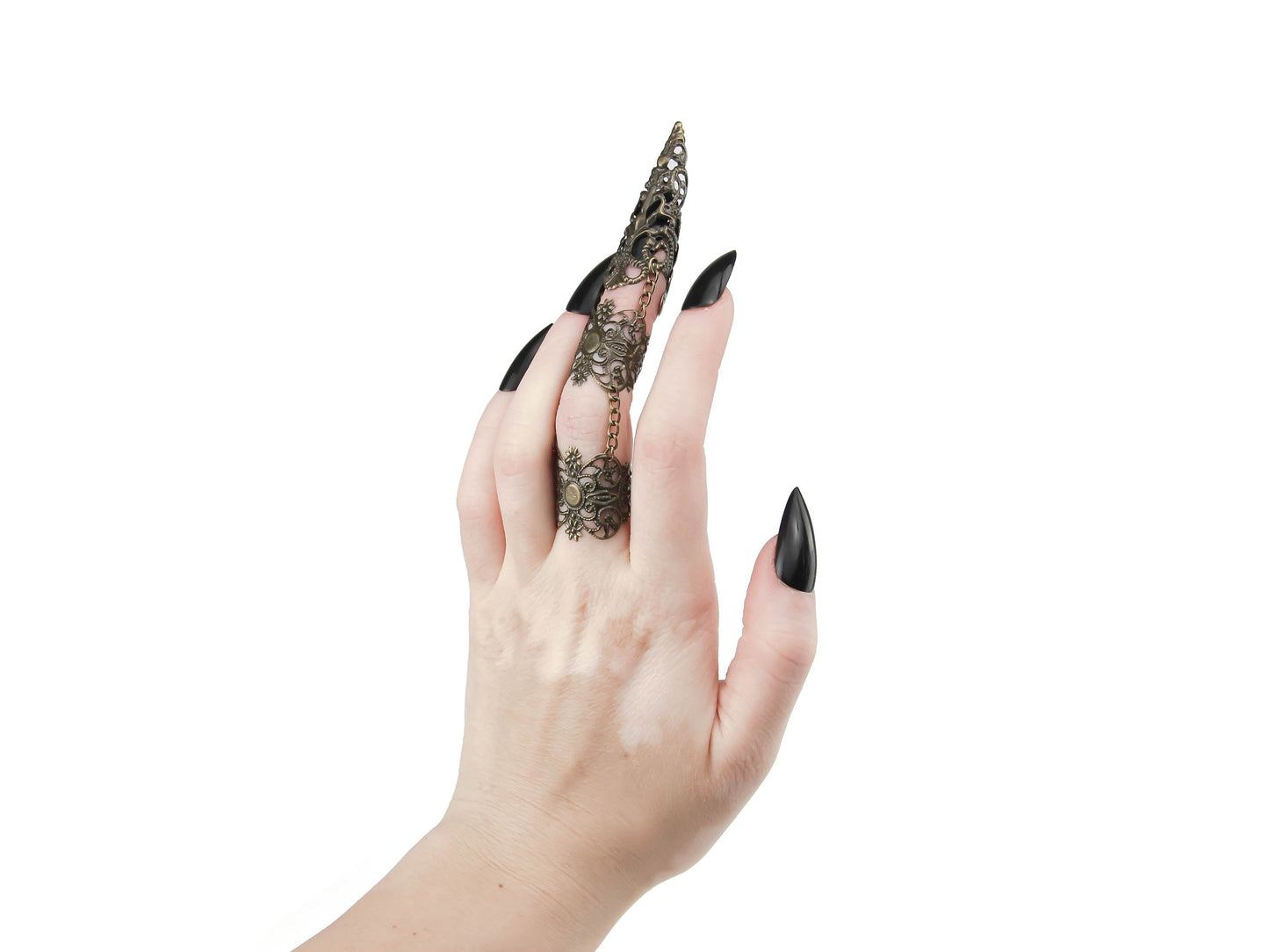 A hand elegantly displays Myril Jewels' full finger double ring in bronze, extending into a long, ornate claw over the nail, exuding a luxurious golden shimmer. This distinctive piece exemplifies neo-goth craftsmanship, ideal for those drawn to the dark-avantgarde and gothic-chic aesthetic. It's a bold statement accessory, perfect for Halloween, enhancing a minimal goth look, or as a dramatic addition to rave party and festival jewelry collections