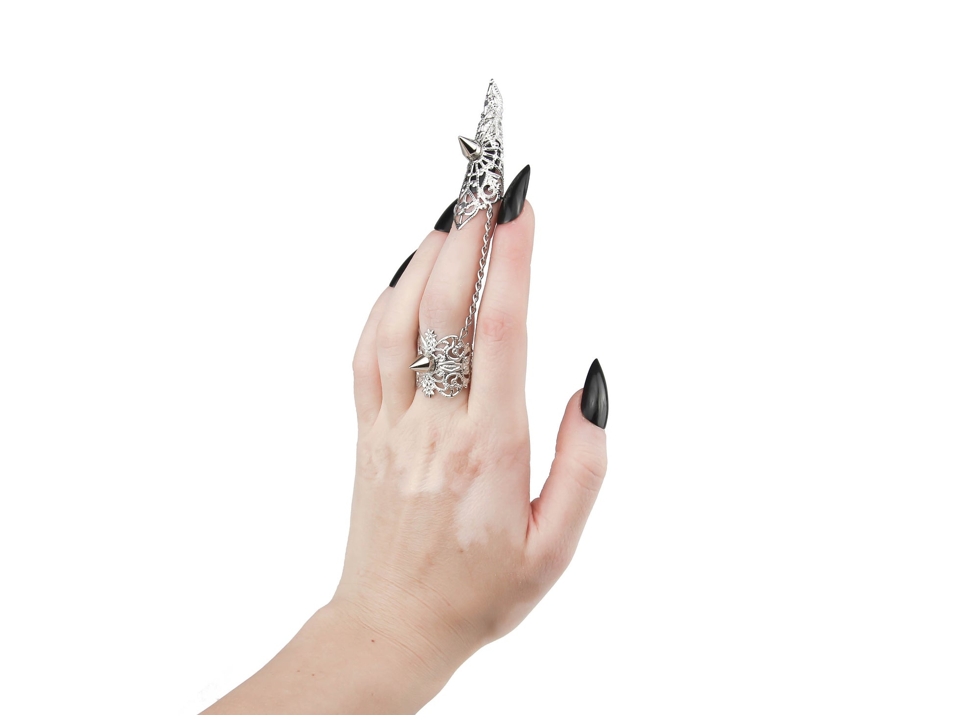 A hand is adorned with a striking Myril Jewels silver claw ring, featuring delicate filigree and bold studs. This studded ring embody the essence of neo-gothic luxury, perfect for anyone looking to add a touch of dark, avant-garde elegance to their Halloween or everyday gothic-chic style.