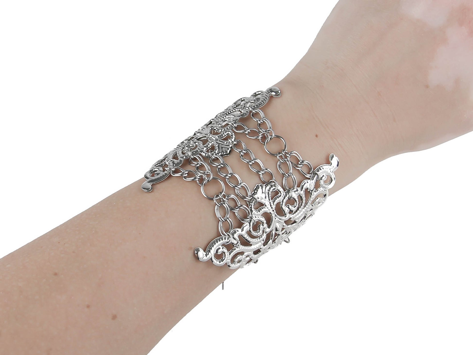 A detailed view of a Myril Jewels gothic bracelet, featuring elaborate silver filigree patterns linked to chains, draping elegantly over a slender wrist. This accessory is perfect for adding a touch of neo-goth drama and sophistication to any outfit, suitable for those who cherish gothic-chic, Witchcore, or bold statement jewelry.