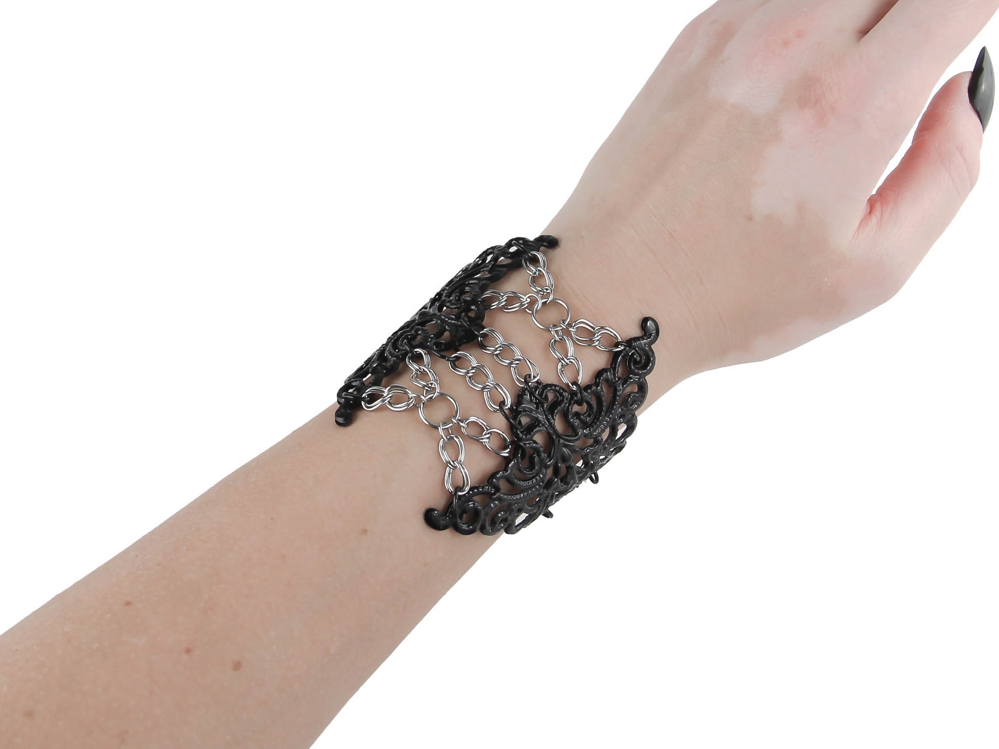 On display is a dark, intricately designed gothic bracelet from Myril Jewels, exemplifying neo-goth craftsmanship. It’s an ideal accessory for anyone drawn to the dark-avantgarde aesthetic, whether for a Halloween event, a bold statement at a rave party, or as a distinctive everyday piece.
