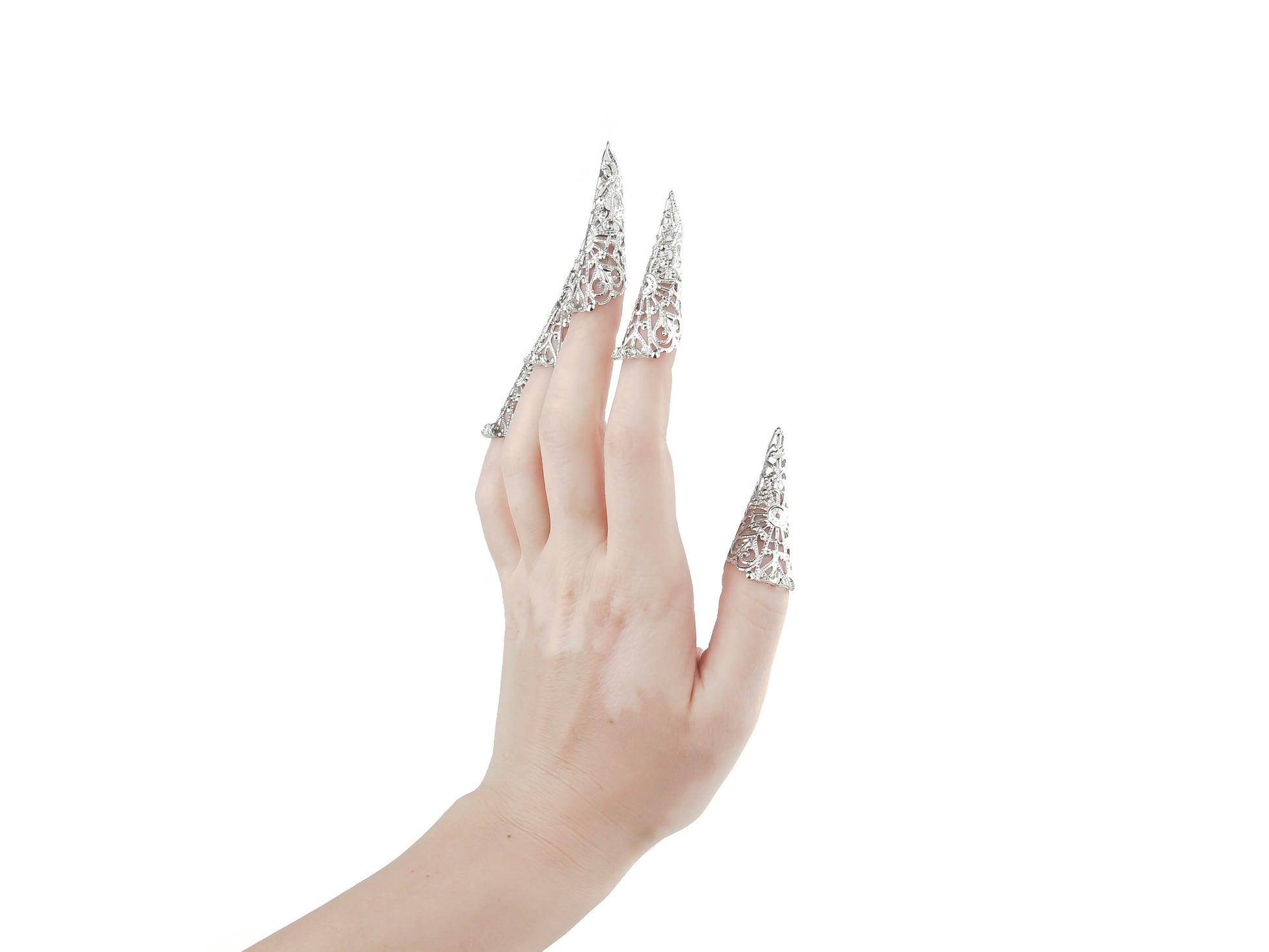 A hand models Myril Jewels' full set of nail claws, exquisitely crafted with intricate silver filigree that emulates the neo-gothic aesthetic. These lavish claw pieces are perfect for those who admire dark-avantgarde fashion, adding an edgy sophistication to any Halloween, punk, or gothic-chic look. They're also ideal for witchcore enthusiasts, and as an eye-catching accessory for rave parties and festival-goers seeking unique, handcrafted jewelry.