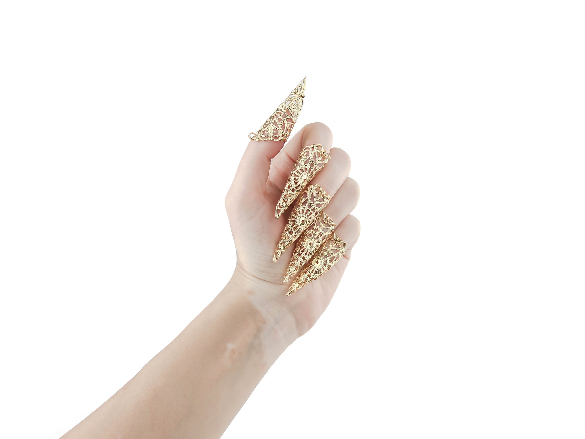 A hand is adorned with a full set of Myril Jewels gold nail claw jewelry, each piece detailed with ornate filigree that captures the essence of neo-goth style. This striking dark-avantgarde accessory set is perfect for gothic and alternative style lovers, offering a unique addition to Halloween costumes, punk fashion, or as an everyday expression of gothic-chic. It's also ideal for enhancing the dramatic flair of witchcore, whimsigoth, or minimal goth attire, and for making a statement at rave parties