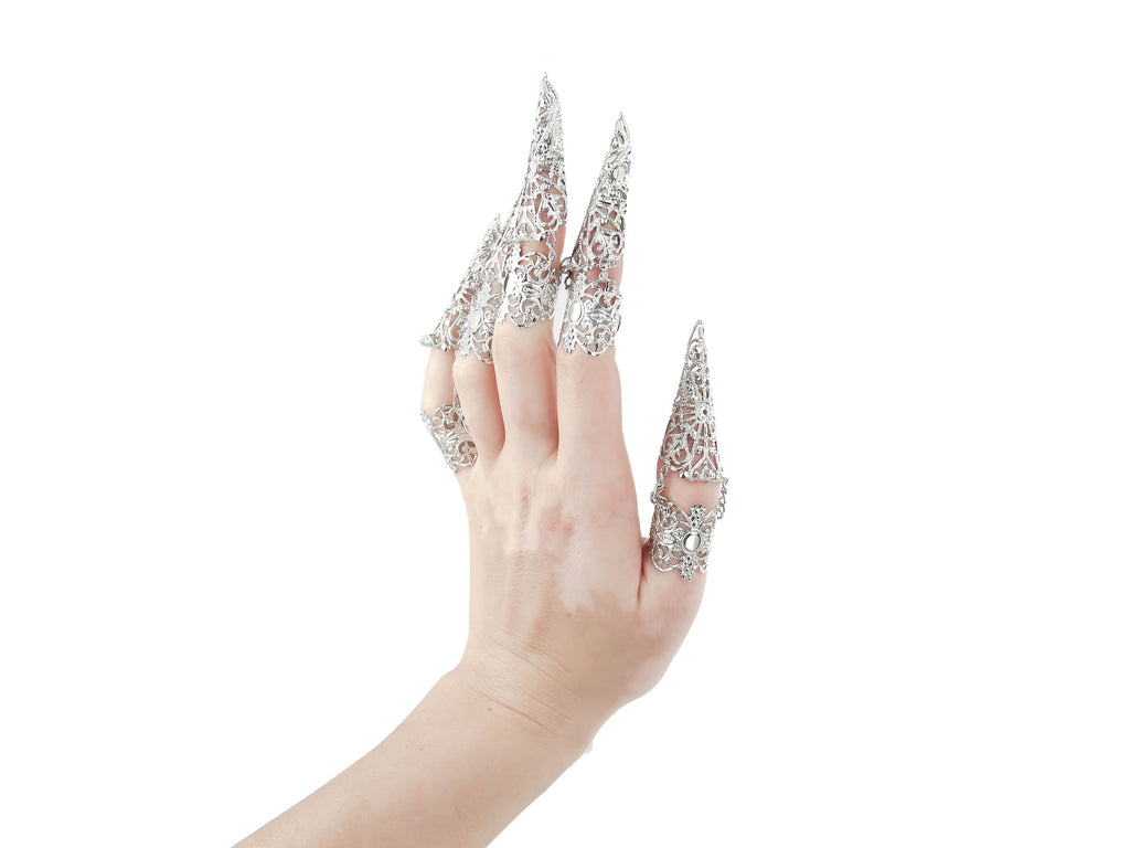 Adorn your hand with the Myril Jewels full hand set of midi rings, designed with an edgy claw-like silhouette for a neo-gothic statement. Perfect for gothic and alternative styles, these intricate silver rings are ideal for Halloween, adding a punk touch to your wardrobe. Their elaborate design captures the essence of gothic-chic jewellery, making them a staple for whimsigoth and witchcore aesthetics. Whether it's everyday wear or as a bold highlight for rave parties and festivals