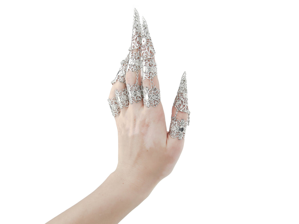 Myril Jewels presents a full hand set of armored claw rings, meticulously crafted with a filigree design that speaks to the heart of gothic opulence. This striking hand jewelry, perfect for those who adore dark avant-garde fashion, is a statement piece for Halloween, Neo Gothic celebrations, and Gothic-chic events. It's an alluring accessory for the whimsigoth, witchcore, and minimal goth audience, and a show-stopping addition for drag queens and dramatic performances