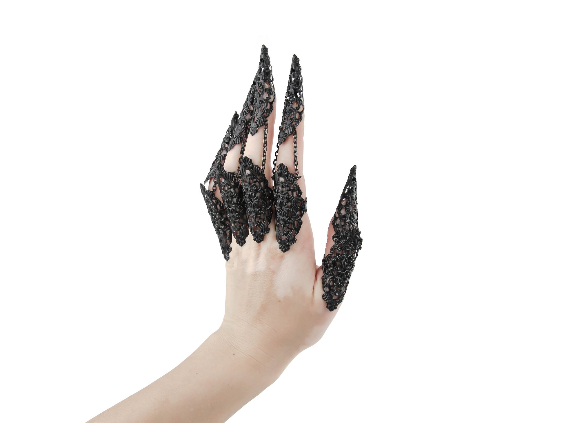 A hand models a full set of ornate black claw rings, designed by Myril Jewels with a neo-gothic flair. These striking pieces merge dark avant-garde artistry with Halloween and punk jewelry influences, perfect for whimsigoth and witchcore styles or as a distinctive accessory for rave parties and festivals. They're also a bold choice for everyday wear, offering an edgy touch to any outfit, and make thoughtful gifts for those with a goth girlfriend or friends who love statement jewelry.
