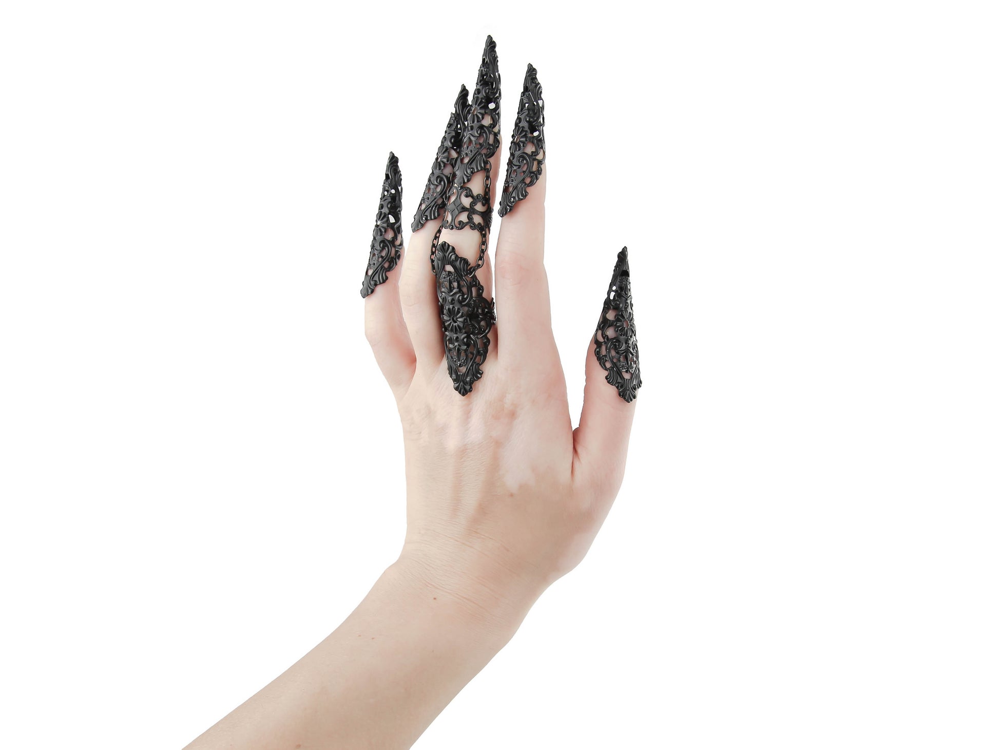 A hand is elegantly adorned with Myril Jewels' black full finger claw ring and black metal claws, each piece showcasing intricate filigree work. The neo-gothic design perfectly embodies the brand's dark-avantgarde ethos, suitable for gothic, whimsigoth, and witchcore styles. These bold statement pieces are ideal for Halloween, everyday wear, or as a dramatic accessory for rave parties and festivals, highlighting Myril's commitment to unique gothic-chic jewelry.