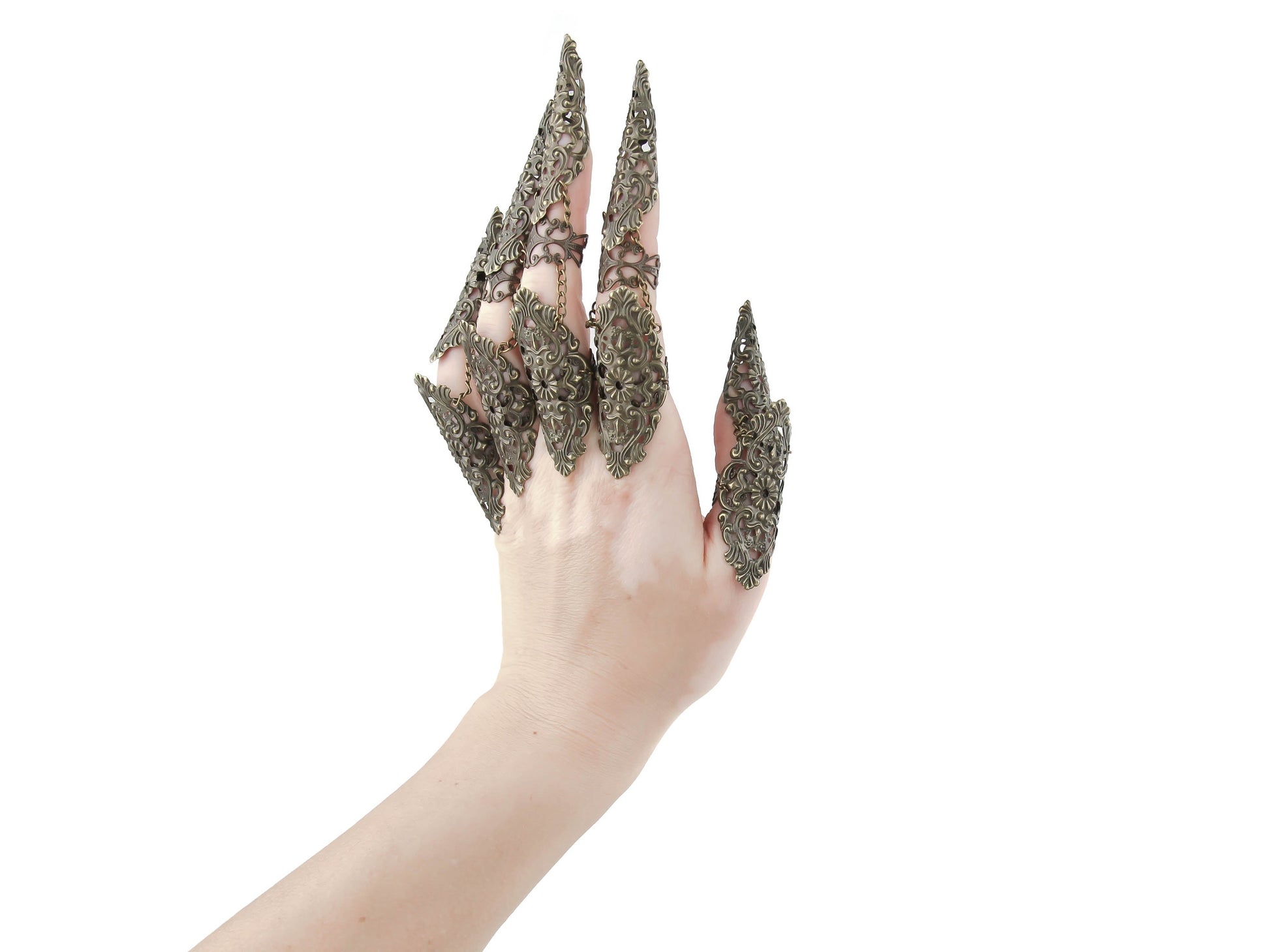 A hand strikingly showcases Myril Jewels' bronze metal lace finger armor rings, a bold statement accessory aligning with the Neo Gothic and Witchcore aesthetics. Ideal for Halloween, Gothic-chic events, or everyday wear for Punk and Gothic Lolita enthusiasts, these handcrafted rings are a hallmark of whimsigoth elegance.