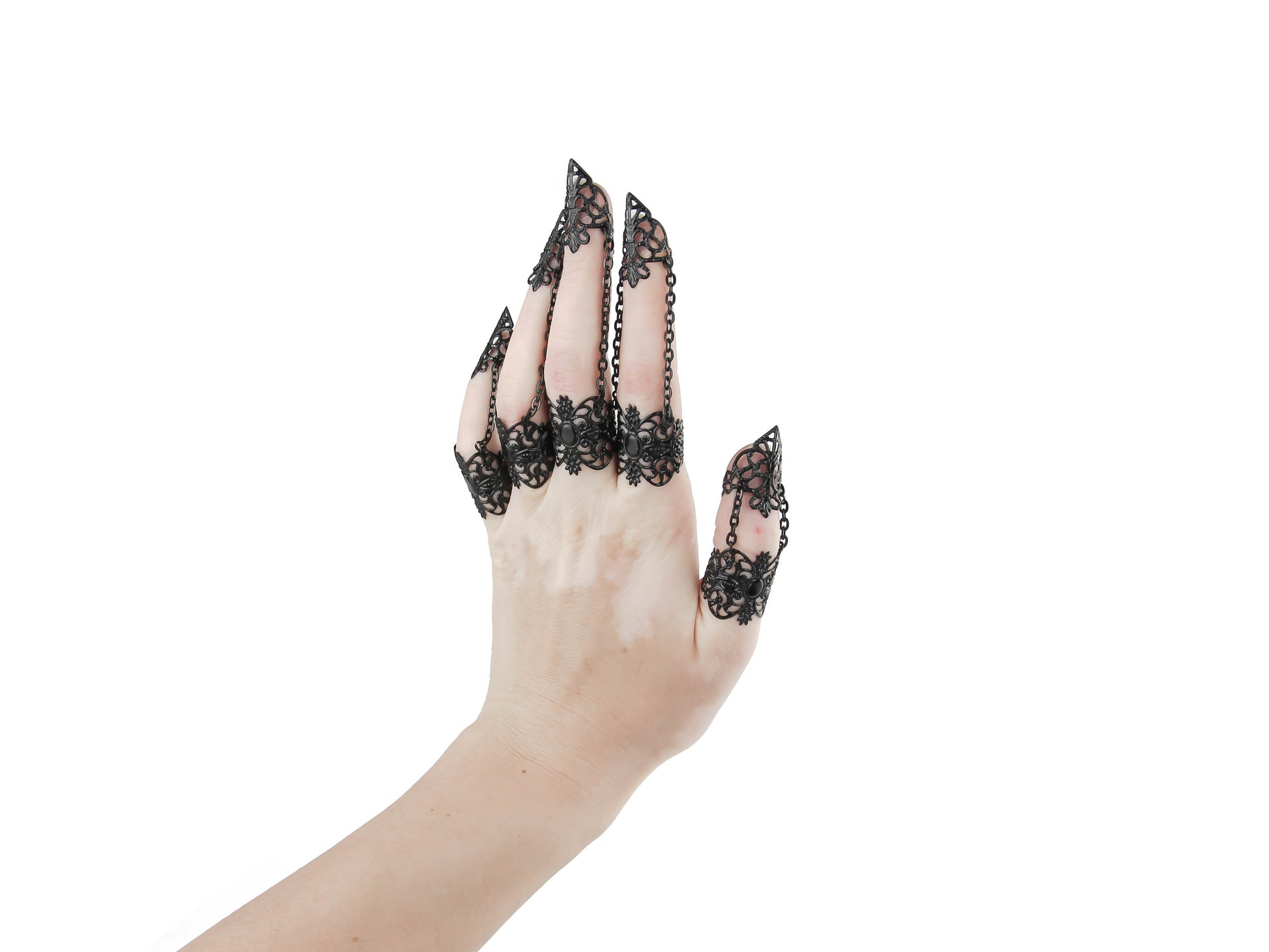 A hand models a full set of ornate black claw rings, designed by Myril Jewels with a neo-gothic flair. These striking pieces merge dark avant-garde artistry with Halloween and punk jewelry influences, perfect for whimsigoth and witchcore styles or as a distinctive accessory for rave parties and festivals. They're also a bold choice for everyday wear, offering an edgy touch to any outfit, and make thoughtful gifts for those with a goth girlfriend or friends who love statement jewelry.