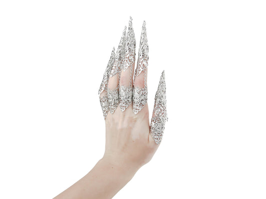 Captured is a full hand set of Myril Jewels claw rings, each piece flowing into long, slender claws that evoke the essence of neo-gothic design. These silver filigree rings, perfect for dark avant-garde enthusiasts, are an impeccable choice for enhancing Halloween attire, gothic-chic fashion, or making a bold statement at rave parties, festivals, or in a drag queen's dazzling ensemble.